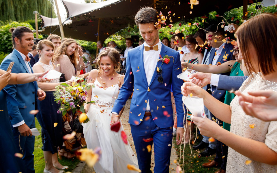 een bruid en bruidegom worden overgoten met confetti