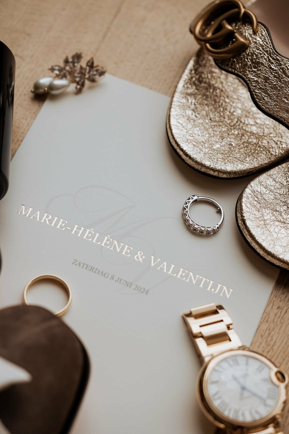 een close-up van een paar sandalen, een horloge en andere items op een tafel