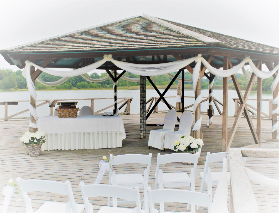 een prieel met witte stoelen en een luifel