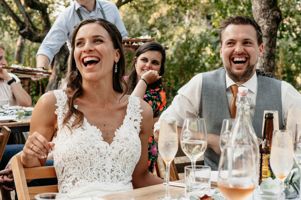 een bruid en bruidegom die lachen op hun bruiloftsreceptie