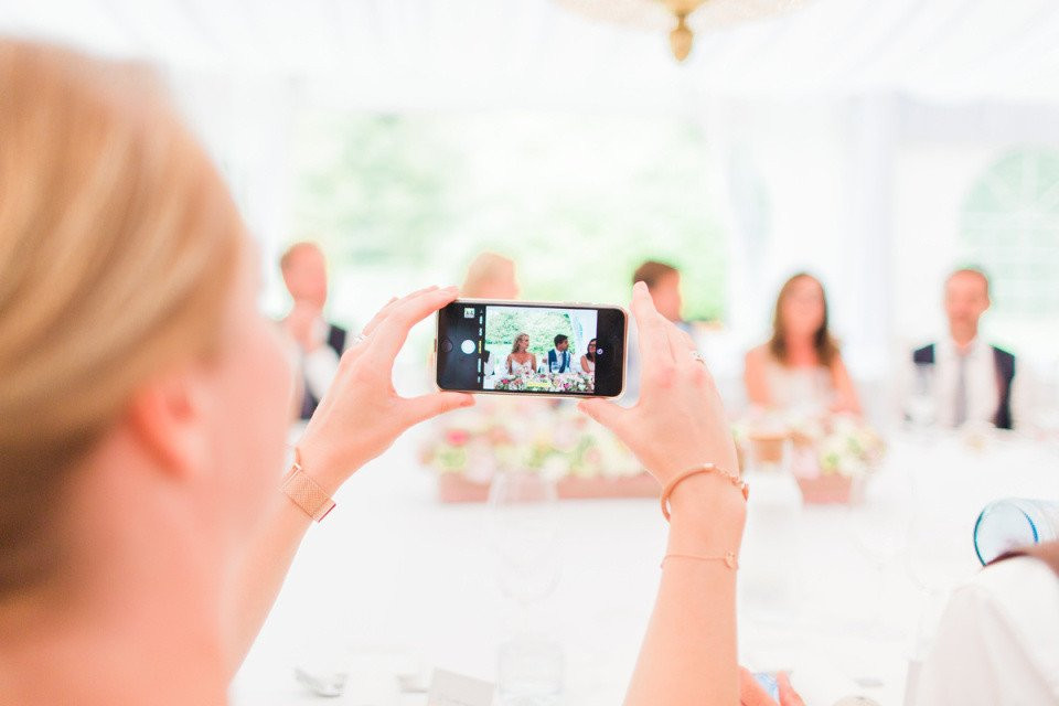 een vrouw die een foto maakt van een bruiloftsfeest