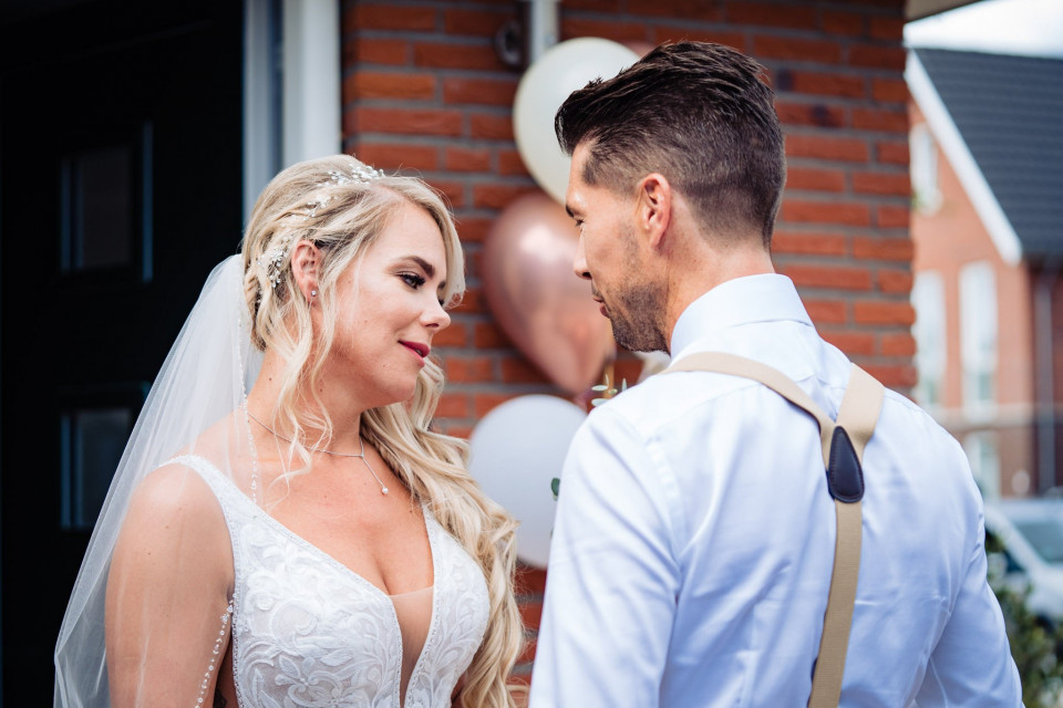 een bruid en bruidegom die naar elkaar kijken