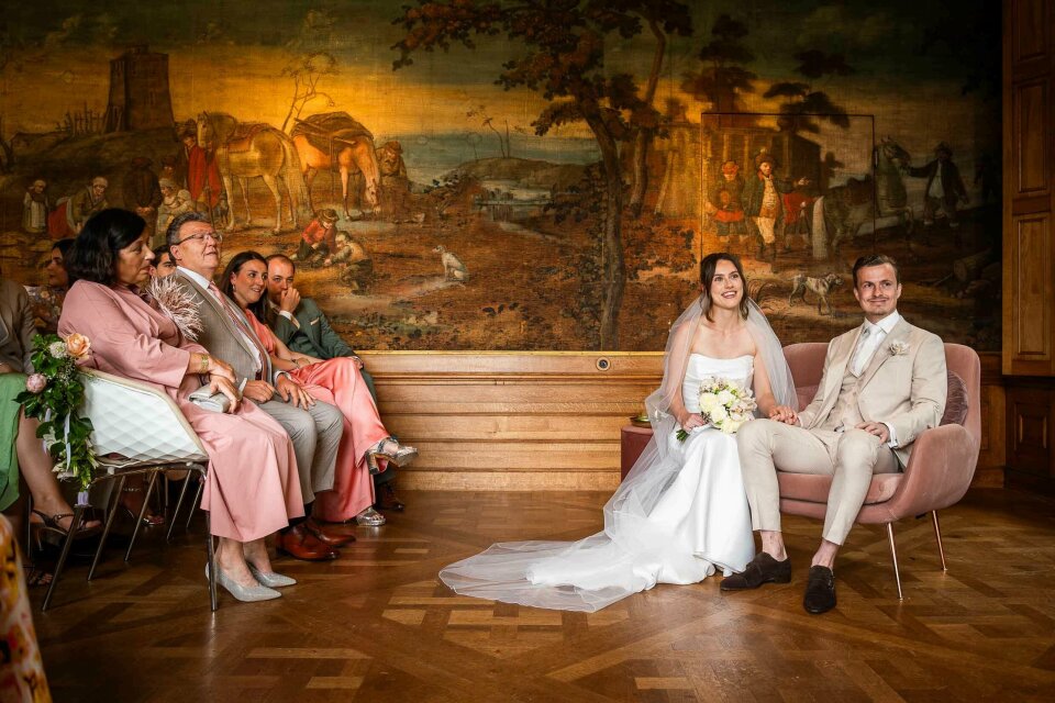 een bruid en bruidegom die voor een groep mensen zitten