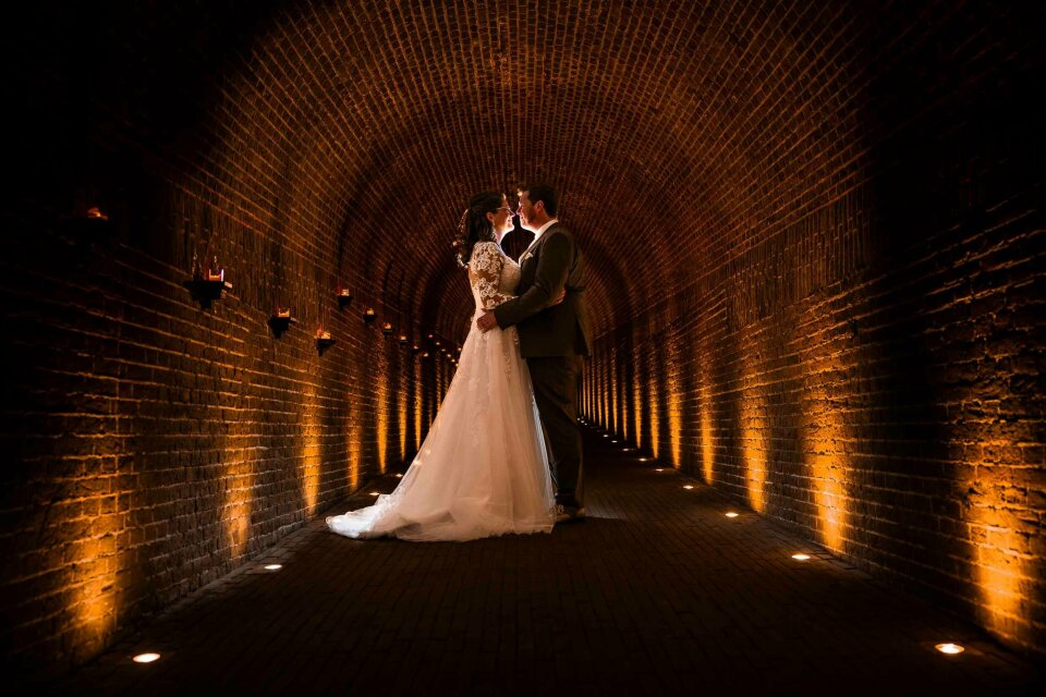 een bruid en bruidegom die 's nachts in een tunnel staan