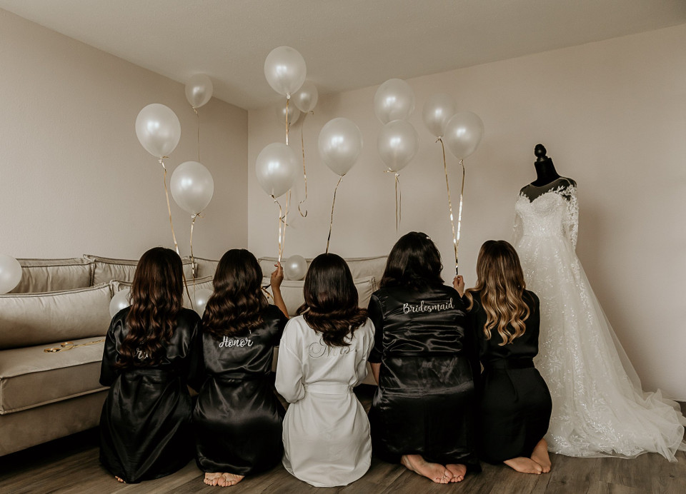 bruidsmeisjes in gewaden die ballonnen vasthouden