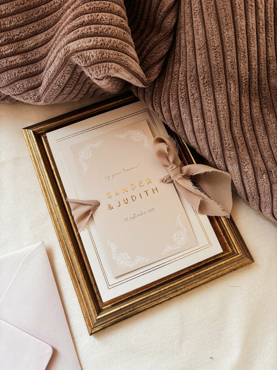 een afbeelding van een trouwuitnodiging op een bed