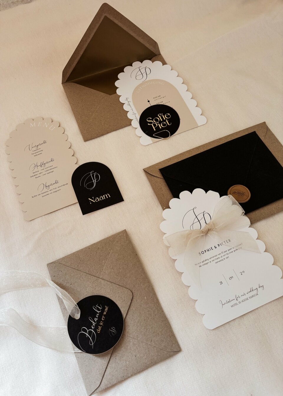 een verscheidenheid aan trouwstationery-items uitgestald op een bed