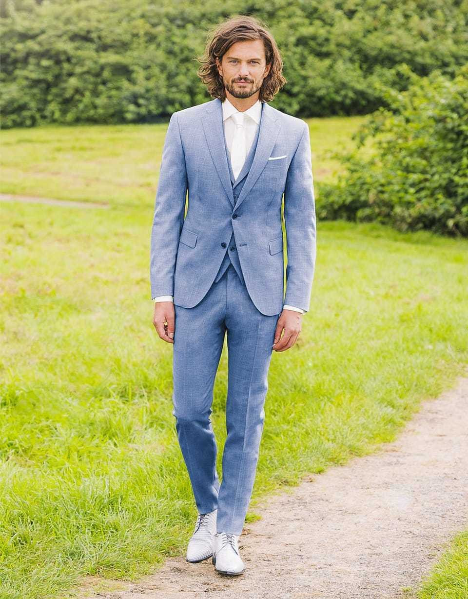een man in een blauw pak en witte schoenen