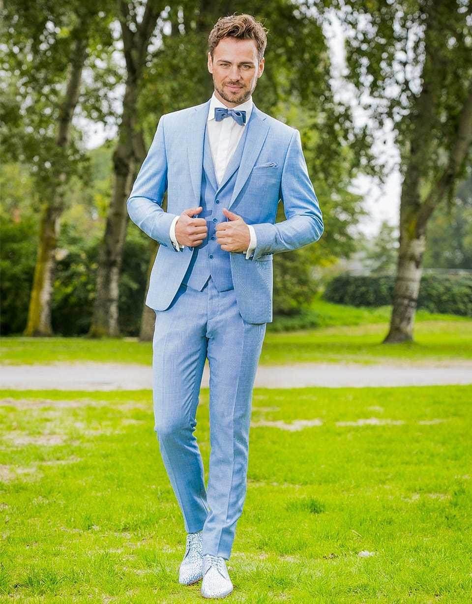 een man in een blauw pak en vlinderdas