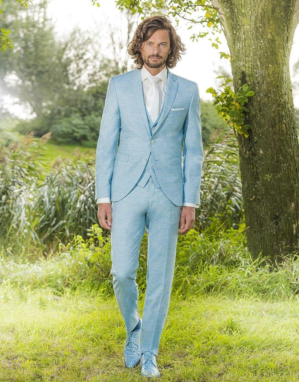 een man in een blauw pak en witte schoenen