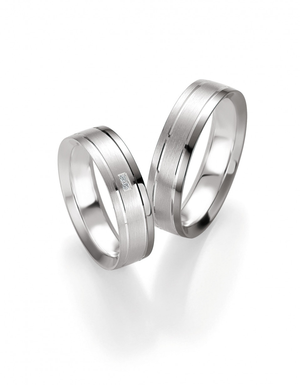 twee trouwringen met diamanten op een witte achtergrond