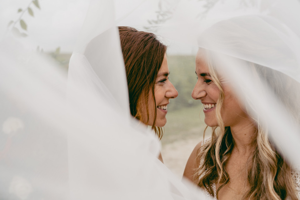 twee vrouwen lachen onder een sluier