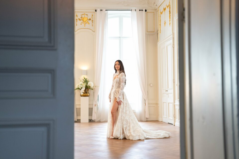 een vrouw in een trouwjurk die in een kamer staat