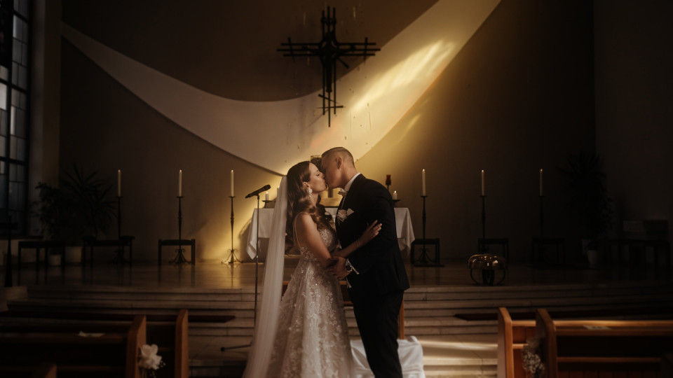 een bruid en bruidegom die in een kerk kussen