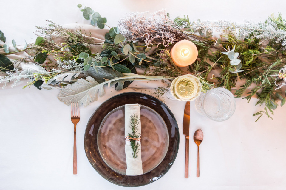 een tafel setting met groen en kaarsen