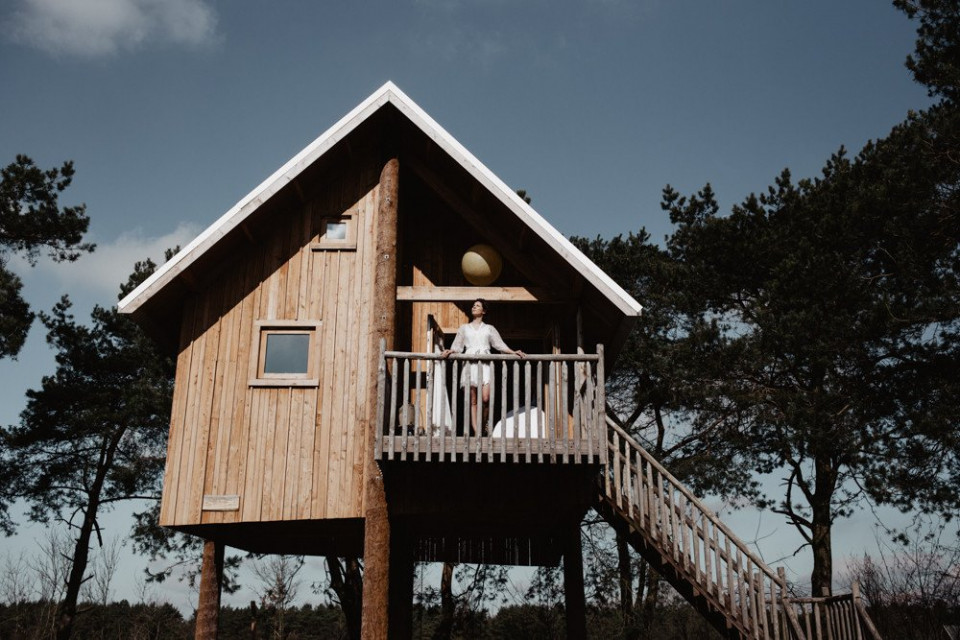 een bruidspaar staat op de top van een boomhut