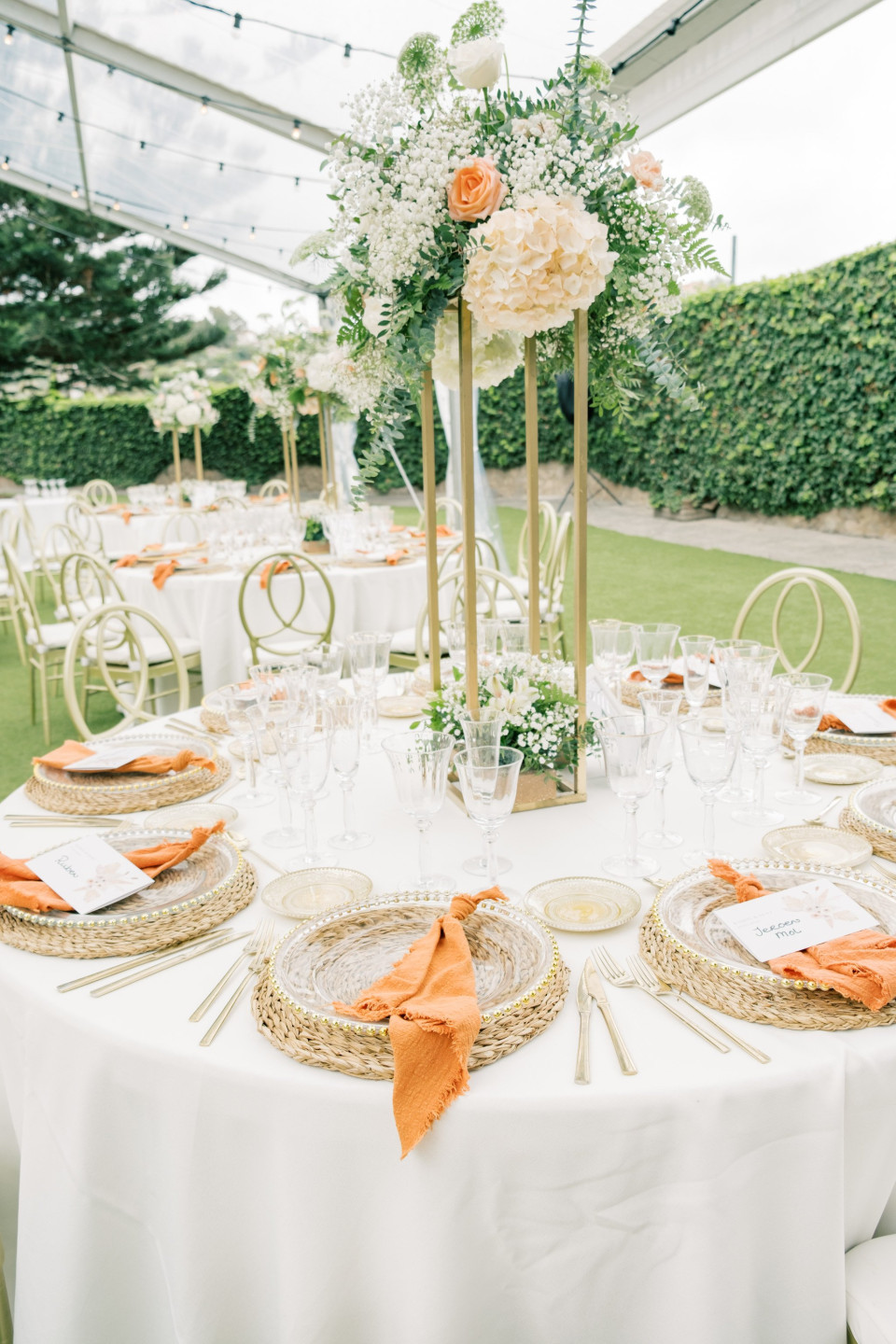 een tafel opgezet met witte en oranje tafeldecoraties