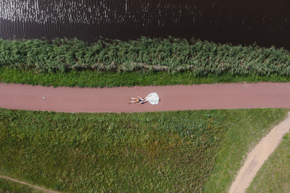 een luchtfoto van een persoon die op een pad ligt naast een waterlichaam