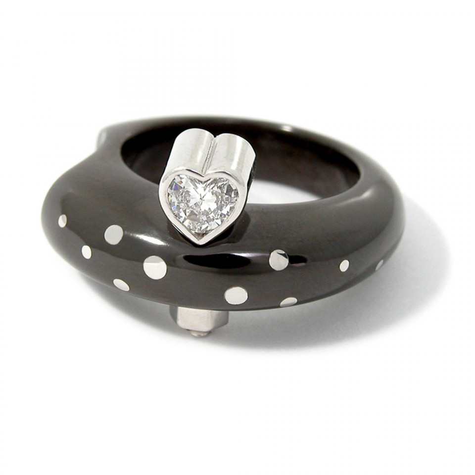een zwart en wit polkadot ring met een hartvormige diamant