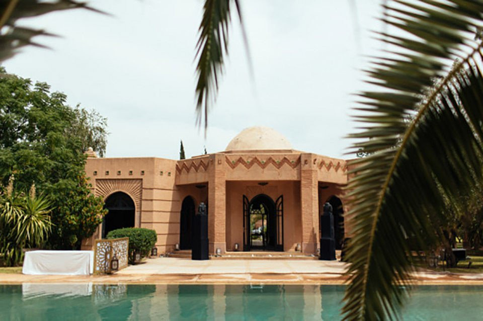 een zwembad omringd door palmbomen en een gebouw