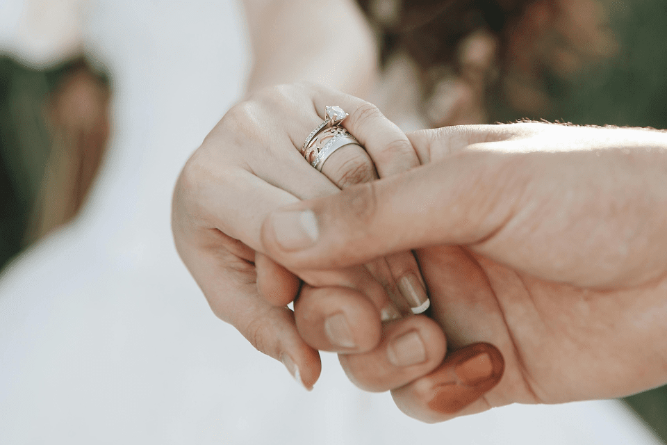 een persoon houdt een trouwring met hun hand