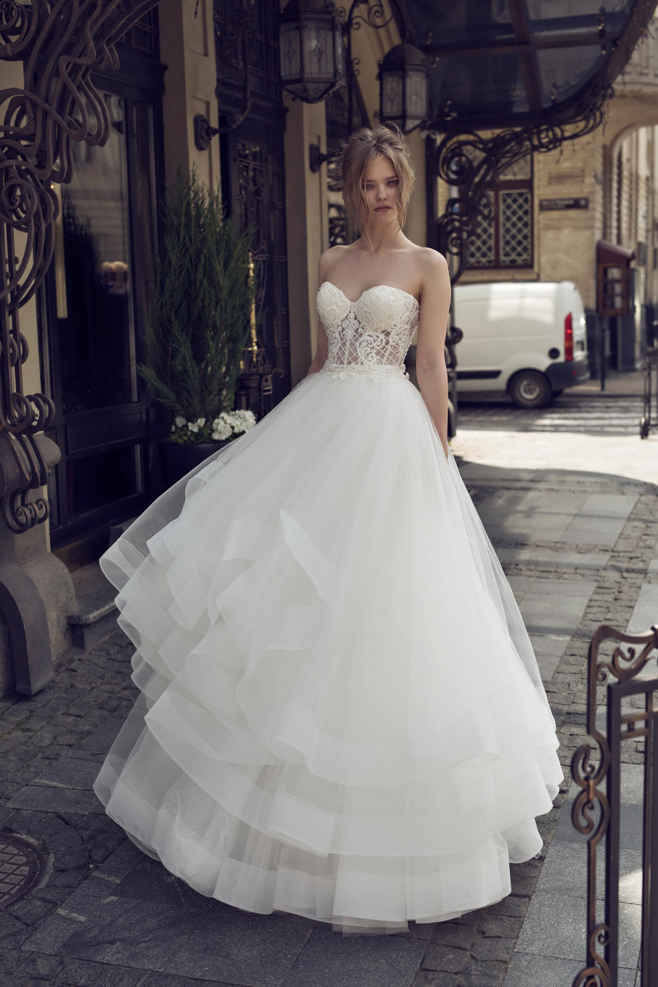 een vrouw in een trouwjurk staat op een straat