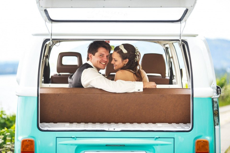 een bruid en bruidegom in een blauwe VW-camperbus