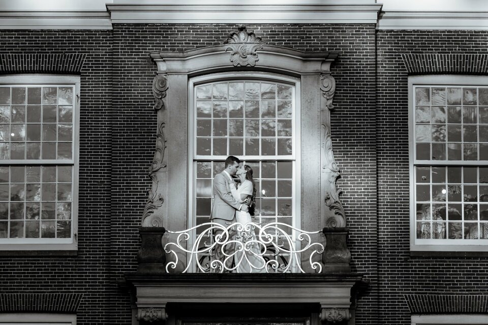 een bruid en bruidegom die op het balkon van een gebouw staan