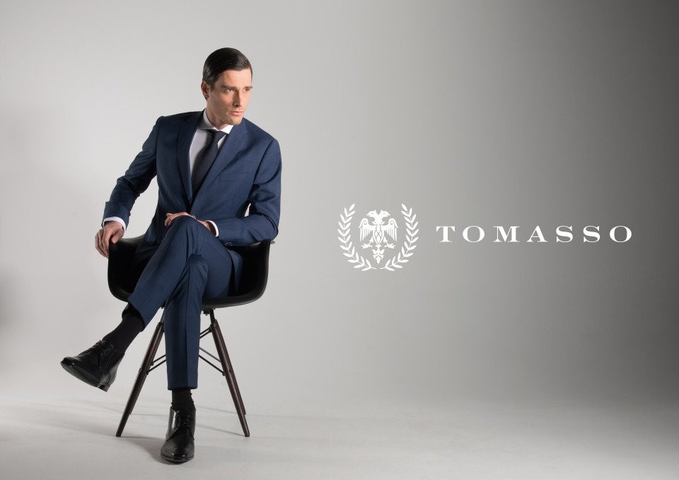 een man in een pak die op een stoel zit