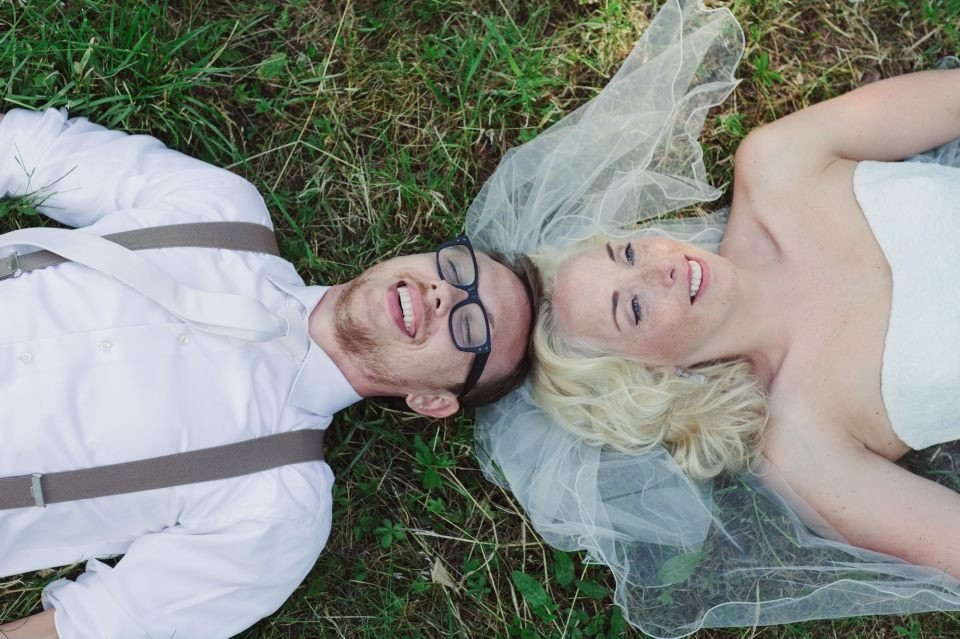 een bruid en bruidegom liggen op het gras
