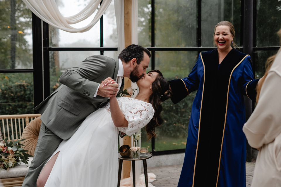 een man en een vrouw die kussen voor een man in een priesterrobe die een mes vasthoudt