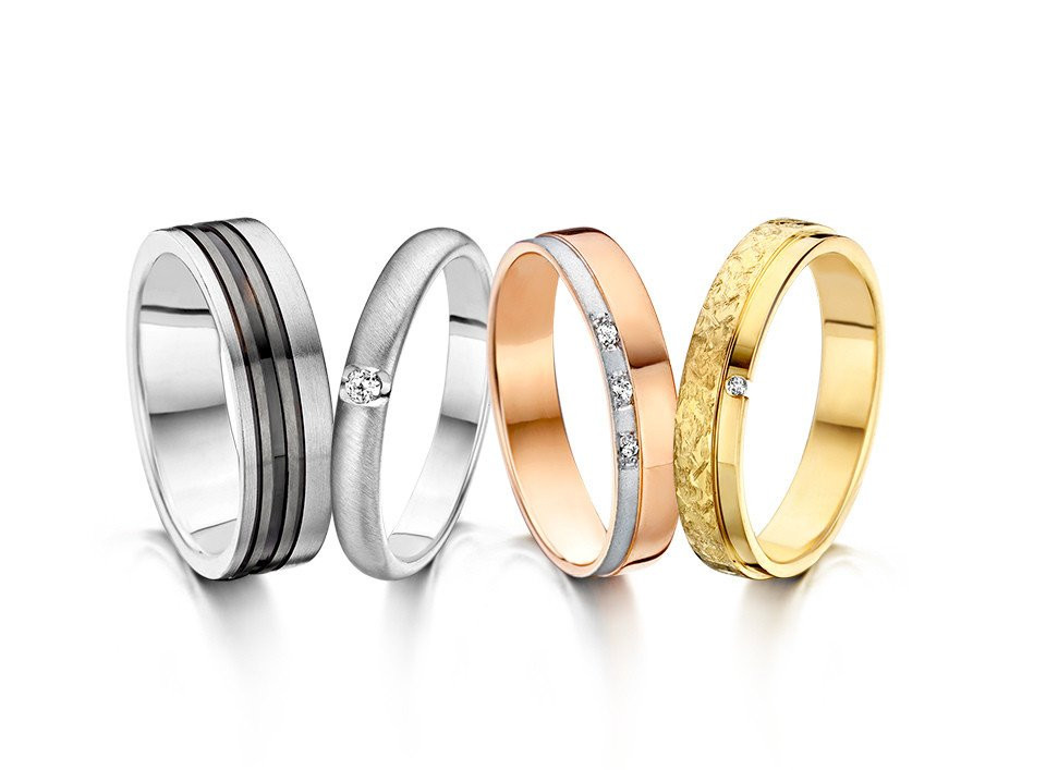 drie verschillend gekleurde trouwringen op een witte achtergrond