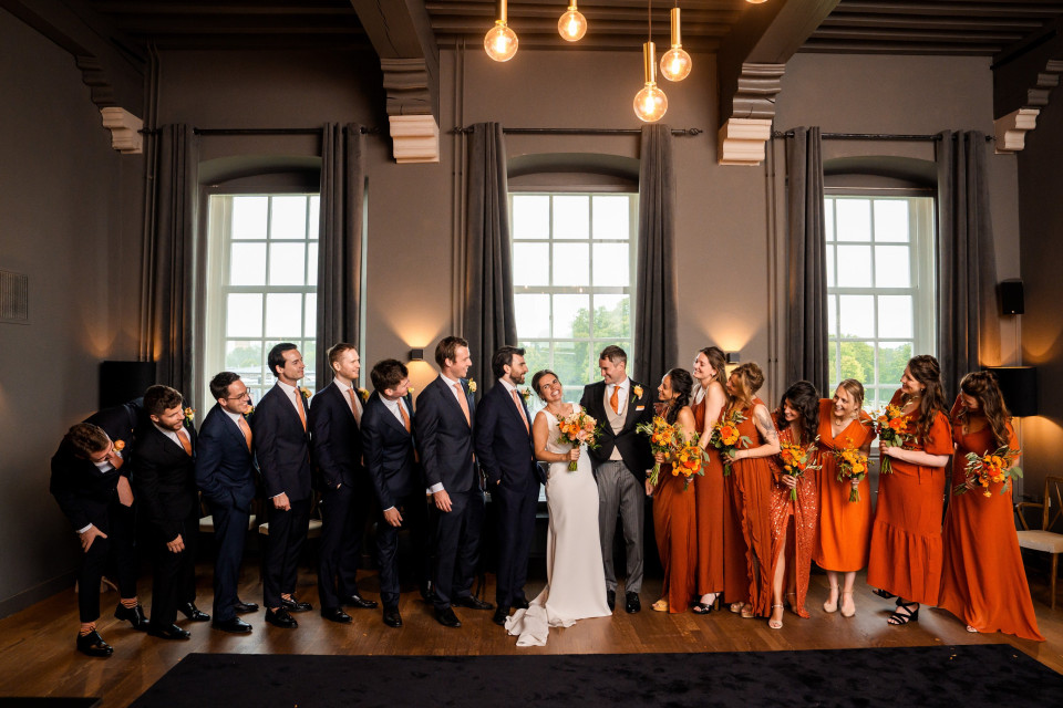 een bruiloftsfeest poseert voor een foto in een elegante kamer