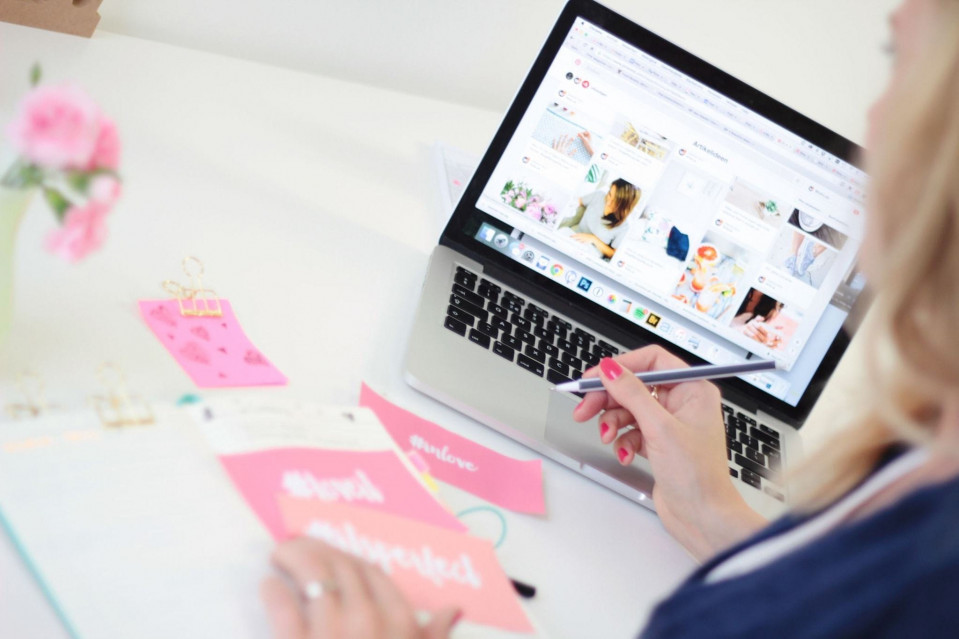 een vrouw werkt op haar laptop terwijl ze aan een bureau zit