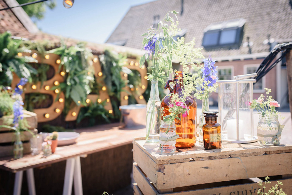 bar met flessen en planten op houten kratten