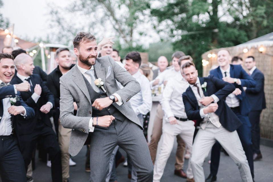bruidegom die danst met bruidsjonkers bij de bruiloftsreceptie