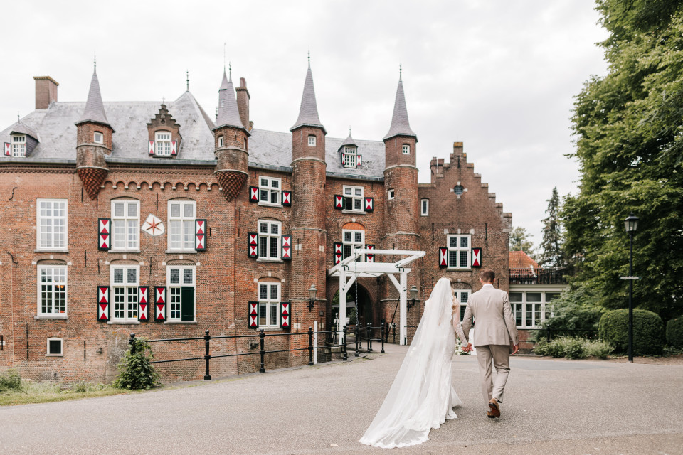 een bruid en bruidegom lopen naar het kasteel