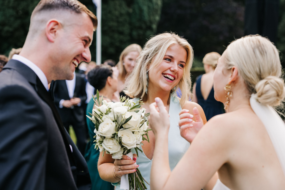 een bruid en bruidegom die lachen met hun vrienden