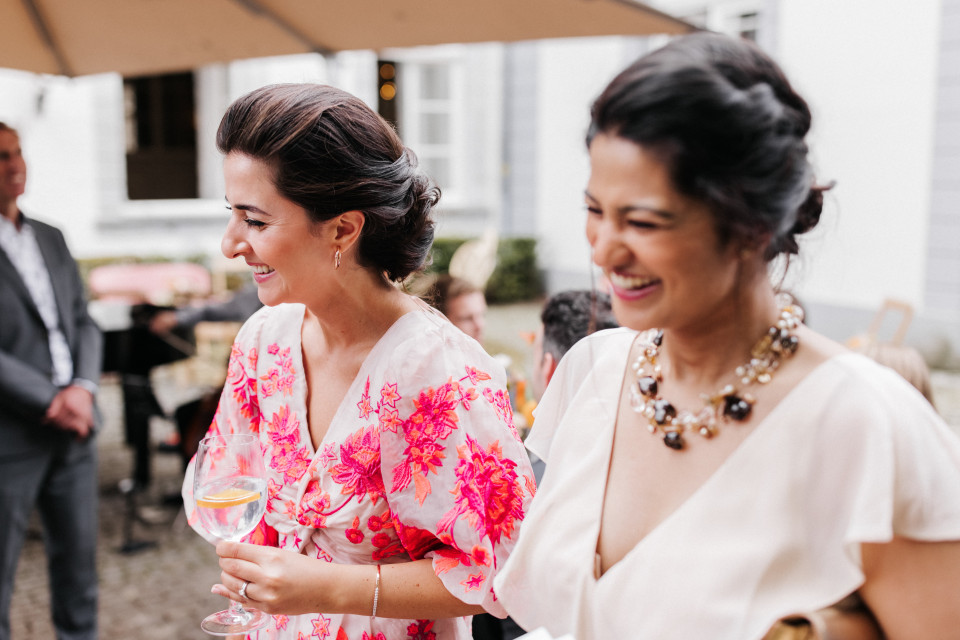 twee vrouwen in jurken die wijnglazen vasthouden
