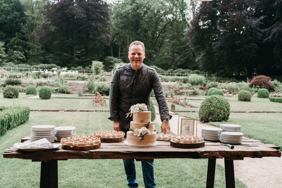een man staat voor een tafel met een taart