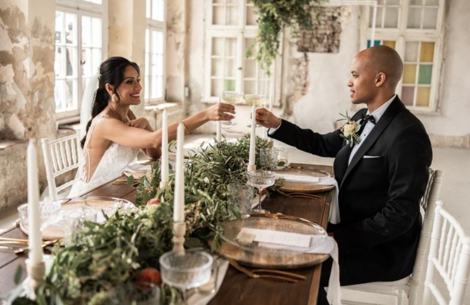 een bruid en bruidegom toosten op hun bruiloftsreceptie