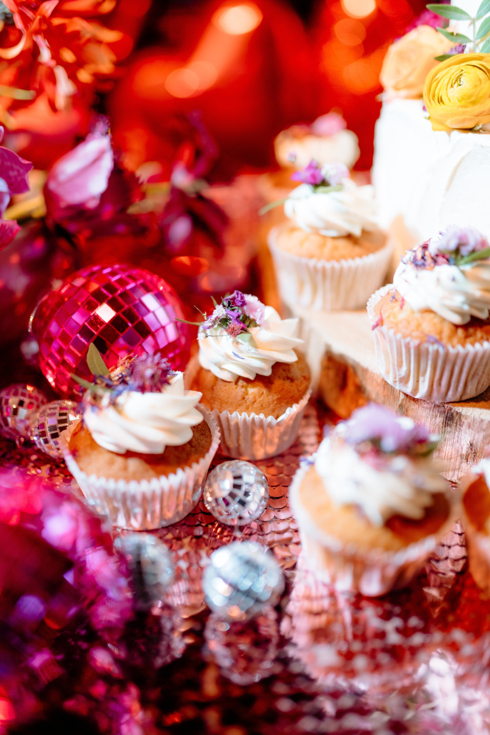 een tafel met cupcakes en bloemen erop