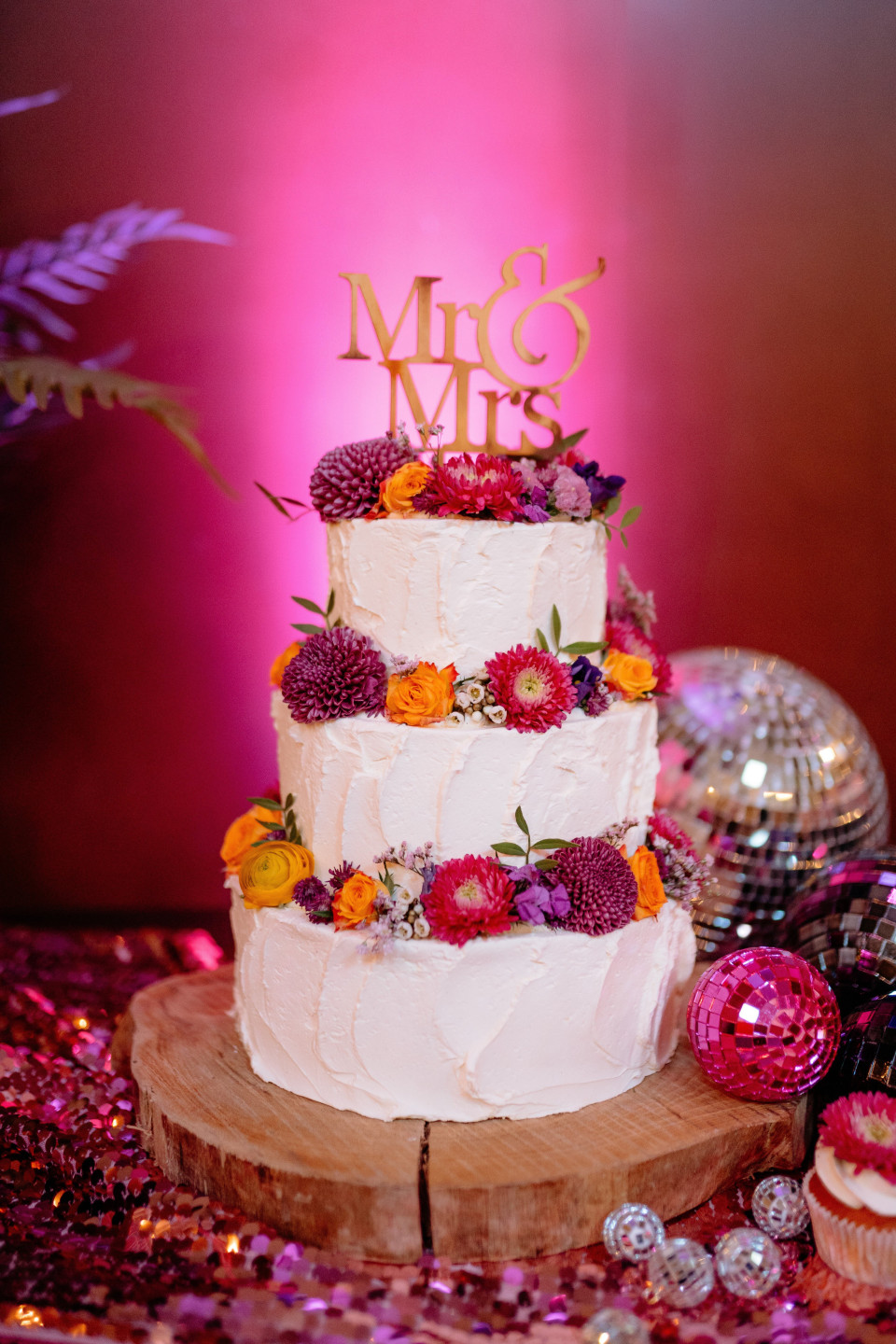 een bruidstaart met een houten bord waarop mr en mrs staat