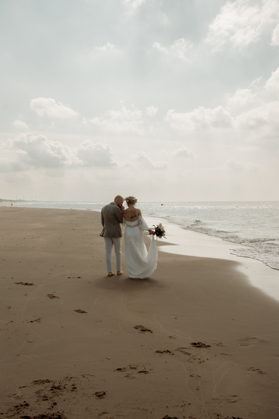 een bruid en bruidegom lopen over het strand