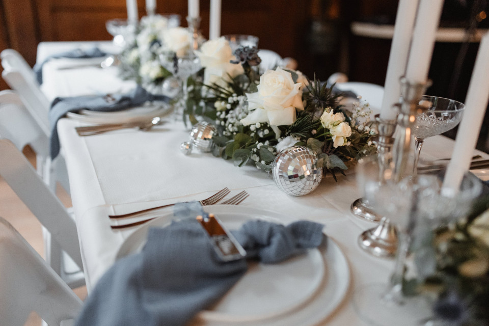 een tafel gedekt voor een trouwreceptie met witte en blauwe bloemen