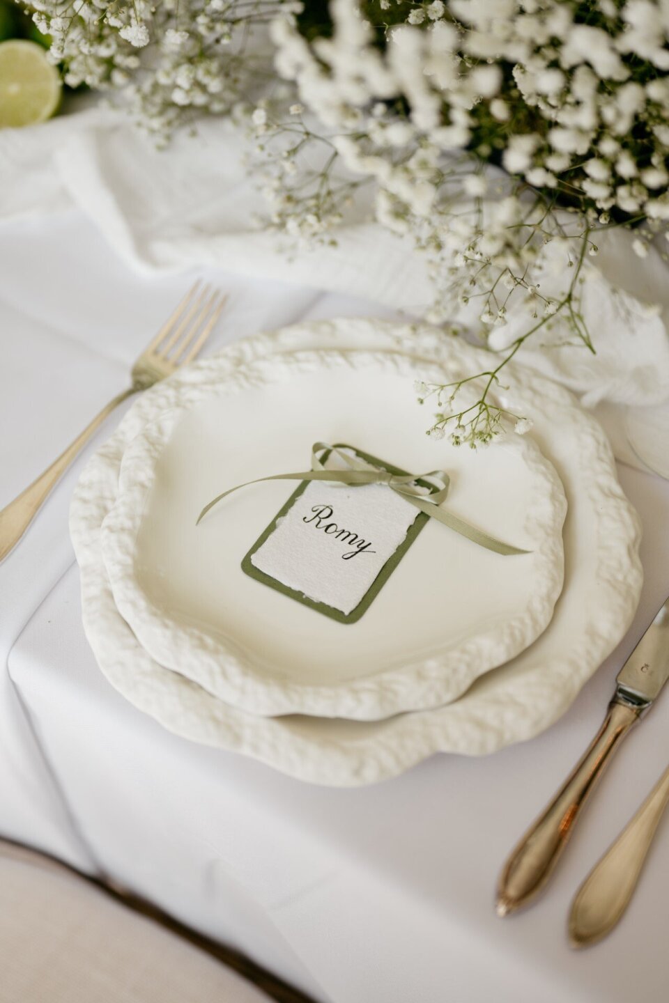 Witte tafelsetting met schelpbord en naamkaartje