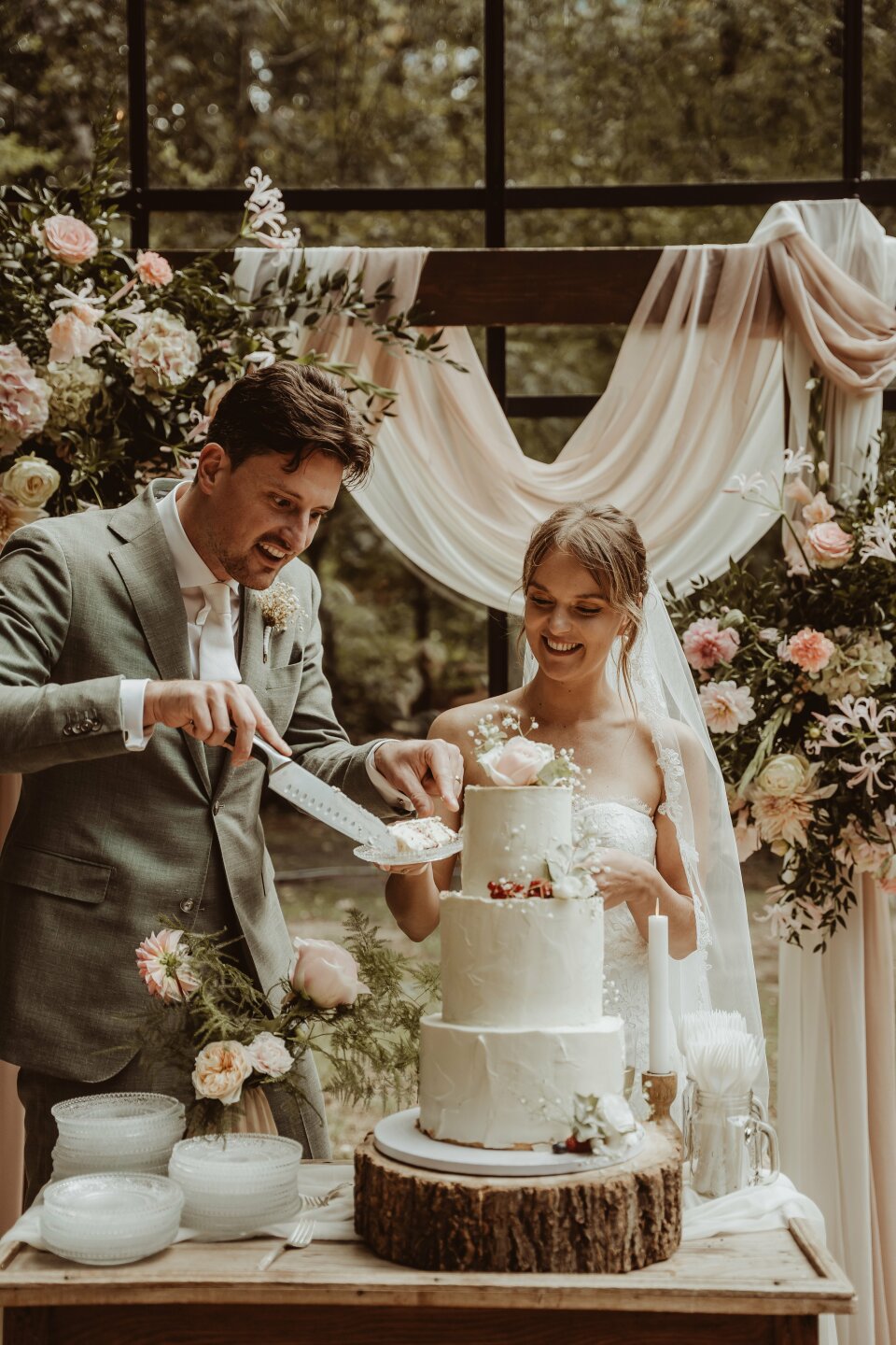 een bruid en bruidegom die hun huwelijkscake snijden