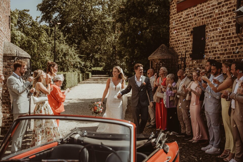 een bruid en bruidegom die voor een menigte mensen staan