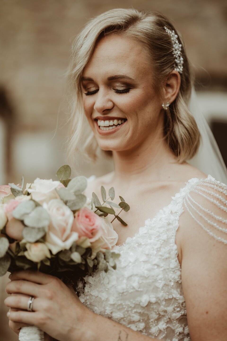 een vrouw in een trouwjurk die een boeket bloemen vasthoudt