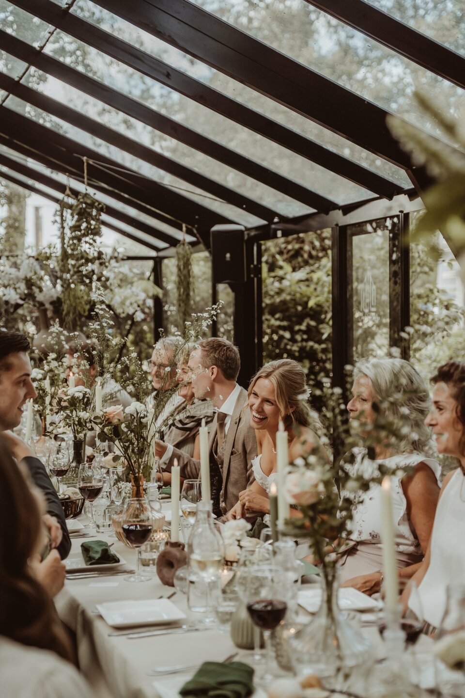 een grote groep mensen die aan een dinertafel zit